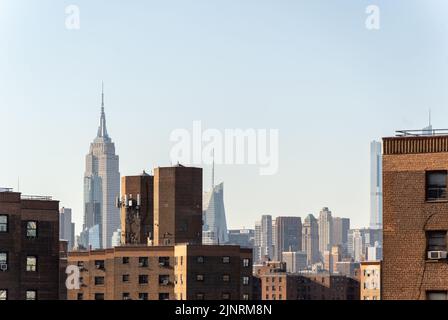 Vue sur l'Empire State Building derrière les bâtiments résidentiels en brique Banque D'Images