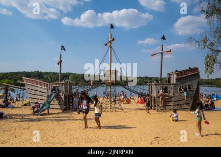 Londres, Royaume-Uni. 13 août 2022. Météo au Royaume-Uni - le bateau pirate sur la plage tandis que les gens apprécient le soleil et le temps chaud à Ruislip Lido dans le nord-ouest de Londres avec des températures qui devraient monter à 34C dans le sud-est. Le sort le plus sec de l’Angleterre depuis 46 ans se poursuit et de nombreuses régions du pays sont désormais officiellement « en sécheresse », selon l’Agence pour l’environnement. Credit: Stephen Chung / Alamy Live News Banque D'Images