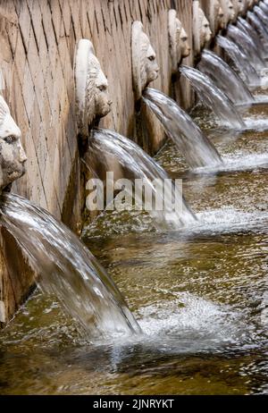 une rangée de fontaines à eau avec des têtes de masque de lion ordonnant de l'eau dans un bain de ville spa ou une gouttière pour repomper à travers la fontaine comme un élément de jardin Banque D'Images