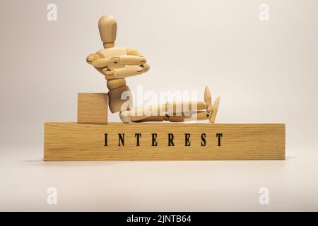 Le mot intérêt est écrit sur la surface en bois. Gros plan Banque D'Images