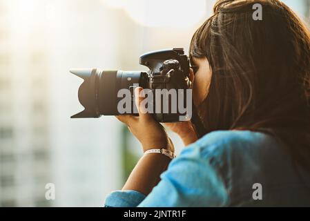 Voir et capturer le monde. Une femme prenant des photos avec son appareil photo à l'extérieur. Banque D'Images
