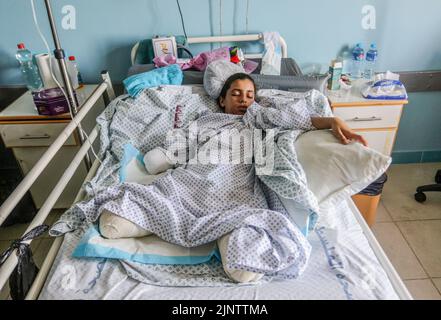 Gaza, Palestine. 13th août 2022. Rahaf Salman, une palestinienne blessée de 11 ans, se couche sur un lit d'hôpital après avoir perdu ses deux jambes et sa main droite lors d'une attaque aérienne israélienne sur Gaza. Le 07 août, Israël et les militants palestiniens à Gaza ont confirmé un cessez-le-feu de médiation égyptienne qui est entré en vigueur après trois jours d'échange d'attaques à la roquette et de frappes aériennes ayant entraîné la mort d'au moins 44 Palestiniens et 360 blessés, selon le Ministère palestinien de la santé. (Photo de Mahmoud Issa/SOPA Images/Sipa USA) crédit: SIPA USA/Alay Live News Banque D'Images