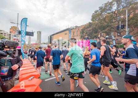 Sydney, Australie.14 août 2022 : plus de 60 000 personnes participent à la course 50th City2Surf à Sydney, la première depuis 2019 après les annulations en 2020 et 2021 en raison des restrictions de Covid-19. La course de quatorze kilomètres, la plus grande du genre au monde, mène les coureurs de Hyde Park hors de la ville, en haut et au-dessus de la colline de coeur de pause et sur la plage de Bondi. Photo: Groupe rouge, y compris les coureurs cédés et ceux qui s'attendent à terminer en moins de 70 minutes crédit: Stephen Dwyer / Alay Live News Banque D'Images