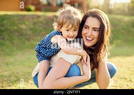 Shes Mams bundle de joie infinie. Une mère se liant avec son adorable petite fille à l'extérieur. Banque D'Images