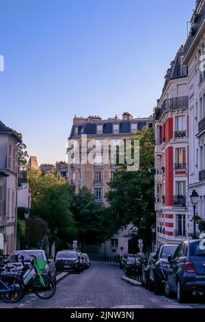 Vue sur une rue de Montmartre, Paris avec des maisons typiques de style Haussmann et des arbres. Banque D'Images
