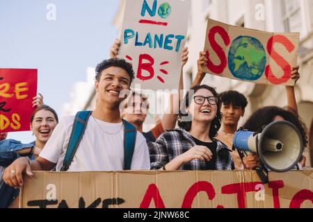 Activisme environnemental de la génération Z. Des jeunes heureux tenant des affiches et des bannières tout en marchant contre le changement climatique. Jeunes multiculturels activis Banque D'Images