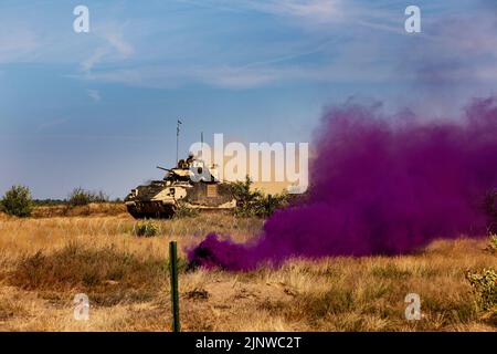 Drawsko Pomorskie, Pologne. 4th août 2022. Un véhicule de combat M2A3 Bradley de l'armée américaine affecté à la « chaos » Company, 1st Bataillon, 68th Armour Regiment, 3rd Armored Brigade combat Team, 4th Infantry Division, avance vers des cibles lors d'un exercice de tir direct à Drawsko Pomorskie, Pologne, 4 août 2022. L'équipe de combat de la Brigade blindée de 3rd, Division d'infanterie de 4th, est parmi les autres unités affectées à la Division d'infanterie de 1st, travaillant fièrement aux côtés des alliés de l'OTAN et des partenaires de sécurité régionaux pour fournir des forces crédibles au corps V, le corps américain déployé en Europe. (Image de crédit : Banque D'Images