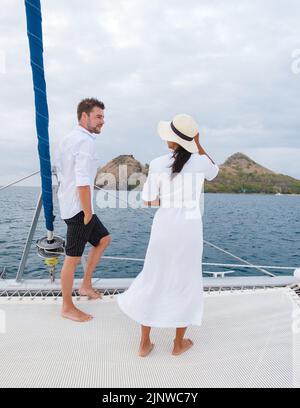 Un couple d'hommes et de femmes regardant le coucher du soleil depuis un bateau à voile dans la mer des Caraïbes Sainte-Lucie ou Sainte-Lucie. Hommes et femmes sur une excursion en bateau avec un bateau à voile Banque D'Images