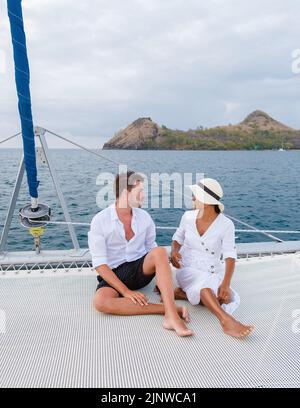 Un couple d'hommes et de femmes regardant le coucher du soleil depuis un bateau à voile dans la mer des Caraïbes Sainte-Lucie ou Sainte-Lucie. Hommes et femmes sur une excursion en bateau avec un bateau à voile Banque D'Images