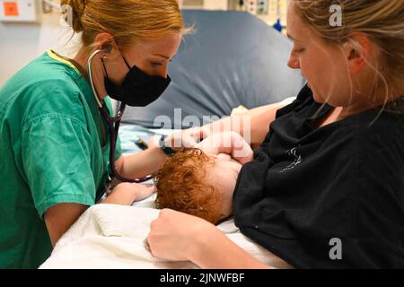 Okinawa, Japon. 3rd août 2022. Sergent d'état-major Stacey Miller, un medic du 155th Medical Group, vérifie les paramètres vitaux d'un nourrisson qui a été admis aux urgences en août. 3, 2022, à l'hôpital naval des États-Unis, Okinawa, Japon. Les membres du groupe médical 155th, Nebraska, et du groupe médical 139th, Missouri, Air National Guard se sont rendus au Japon pour leur formation annuelle. Crédit : U.S. National Guard/ZUMA Press Wire Service/ZUMAPRESS.com/Alamy Live News Banque D'Images