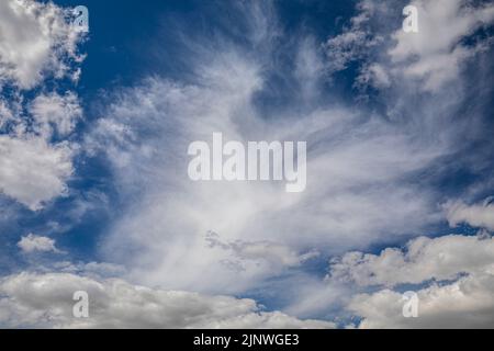 Ciel bleu intense et lumineux avec nuages cirrus blancs et doux, parfait pour les arrière-plans et les ressources graphiques Banque D'Images