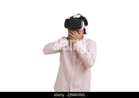 Jeune péruvien stupéfait de porter un casque de réalité virtuelle, isolé. Banque D'Images