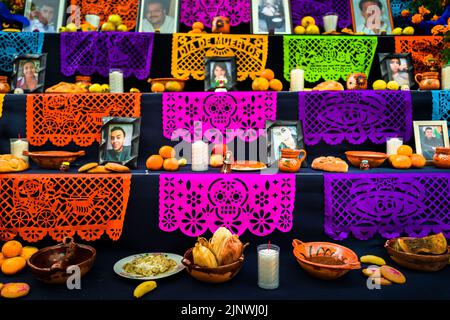 Des produits alimentaires et des drapeaux en papier sont placés sur l'autel des morts pendant les célébrations du jour des morts à Taxco de Alarcón, au Mexique. Banque D'Images