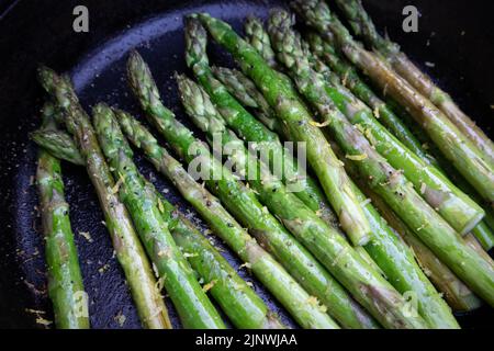 Asperges avec zeste de citron grillées à l'extérieur dans une poêle en fonte Banque D'Images