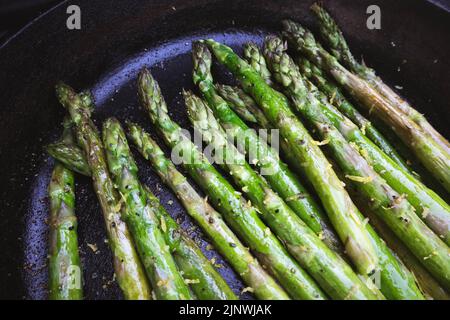 Asperges avec zeste de citron grillées à l'extérieur dans une poêle en fonte Banque D'Images