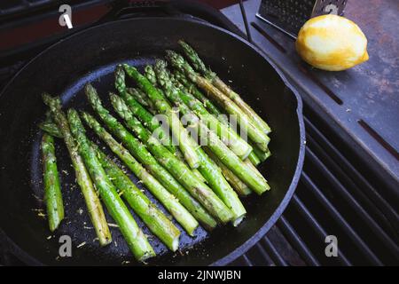 Asperges avec zeste de citron grillées à l'extérieur dans une poêle en fonte Banque D'Images