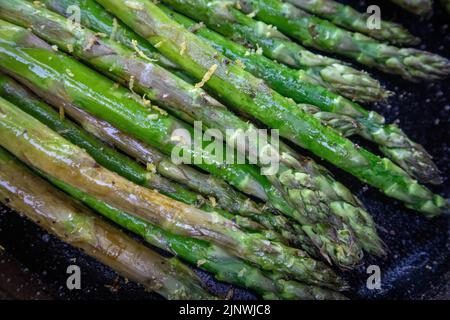 Asperges avec zeste de citron grillées à l'extérieur dans une poêle en fonte Banque D'Images