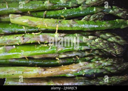 Asperges avec zeste de citron grillées à l'extérieur dans une poêle en fonte Banque D'Images