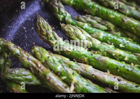 Asperges avec zeste de citron grillées à l'extérieur dans une poêle en fonte Banque D'Images