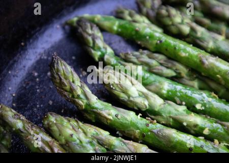 Asperges avec zeste de citron grillées à l'extérieur dans une poêle en fonte Banque D'Images