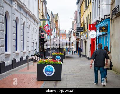 CORK, IRLANDE. 04 AVRIL 2022. Vieille ville. Petite rue à l'architecture traditionnelle et personnes marchant autour. Printemps en Europe Banque D'Images