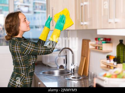 Femme nettoyant les surfaces de la cuisine Banque D'Images