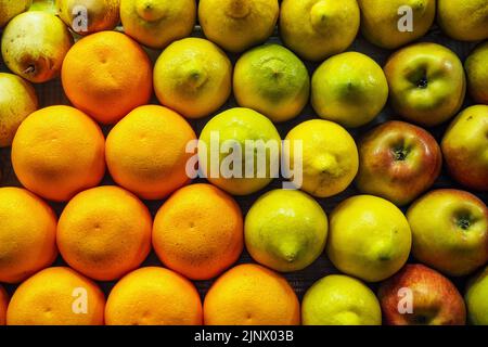 Oranges, poires, citrons et pommes bien agencées sur le marché aux fruits de rue au Maroc Banque D'Images