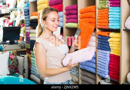 femme client qui prend des serviettes de bain. Banque D'Images