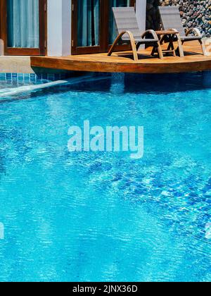 Décoration de piscine avec terrasse en bois près de la chambre à la piscine avec espace de copie, style vertical. Piscine extérieure vide au soleil da Banque D'Images