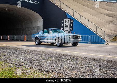 Liban, TN - 14 mai 2022 : vue grand angle à l'angle avant d'une Ford Mustang GT 1967 Fastback conduite sur une route quittant un salon de voiture local. Banque D'Images