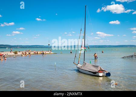 Vue pittoresque de la plage sur la rive sud du lac Balaton avec bateau à voile au premier plan. Banque D'Images