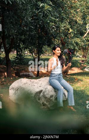 Jeune femme asiatique enregistrant des vidéos avec une caméra pour vlog et les médias sociaux Banque D'Images