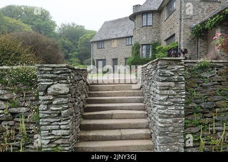 De vieux marches mènent vers la maison et le patio de la pelouse dans le domaine d'une maison de campagne anglaise à Devon Banque D'Images