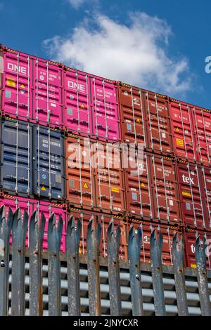 conteneurs d'expédition empilés dans une installation de stockage dans les quais de southampton au royaume-uni, l'expédition contient une variété de couleurs vives de cargaison. Banque D'Images