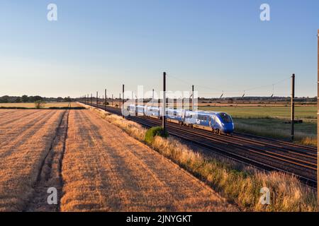 Opérateur d'accès ouvert Firstgroup Lumo classe 803 train électrique sur la voie principale de la côte est à 4 voies dans le Yorkshire passant par la campagne arable Banque D'Images