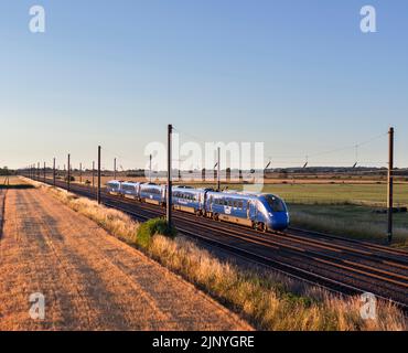 Opérateur d'accès ouvert Firstgroup Lumo classe 803 train électrique sur la voie principale de la côte est à 4 voies dans le Yorkshire passant par la campagne arable Banque D'Images