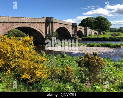 Pont de Dun, au-dessus de l'Esk Sud près de Montrose sur une journée de printemps lumineux avec la végétation de rive au premier plan et une barre de gravier dans la rivière. Banque D'Images