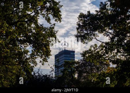 Mercedes Benz star au sommet de la tour Europacenter vue à travers des branches sombres à Berlin, Allemagne en octobre 2018. Banque D'Images