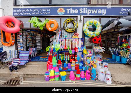 Exposition au bord de la route de flatables colorées et de jouets de plage dans une boutique par le Cobb à Lyme Regis sur la côte jurassique à Dorset, au sud de l'Angleterre Banque D'Images