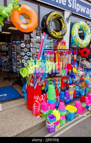 Exposition au bord de la route de flatables colorées et de jouets de plage dans une boutique par le Cobb à Lyme Regis sur la côte jurassique à Dorset, au sud de l'Angleterre Banque D'Images