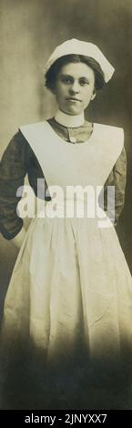 Portrait du début du 20th siècle de l'infirmière en uniforme debout et posant pour le portrait en studio vers 1915 Banque D'Images