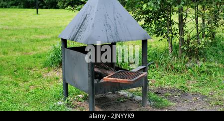 Barbecue avec un toit pour barbecue dans le parc forestier Banque D'Images