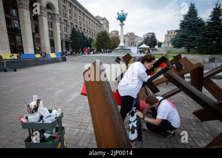 Des artistes peignent des barricades anti-tank de hérisson dans le centre de Kiev. Banque D'Images