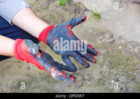 Flou artistique gants sales et étanches. Ouvrir les mains dans des gants de travail usés, protection contre les dommages pendant le fonctionnement, gros plan sur le dos de la nature Banque D'Images