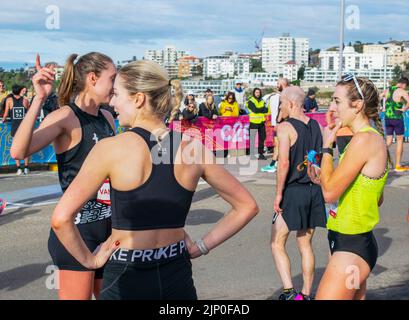 Sydney, Australie, 14 août 2022 : le marathon « City 2 Surf » 2022. Le populaire événement annuel est une course de 14,1 km qui commence dans le centre-ville de Sydney et se termine à Bondi Beach. Photo : Leanne Pompeani, 1st place-getter, course pour femmes (à l'extrême droite) avec d'autres coureuses à la ligne d'arrivée. Banque D'Images