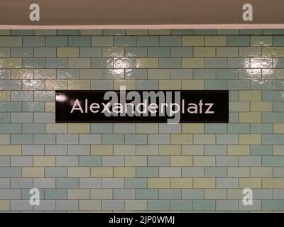 Gare U-Bahn Alexanderplatz dans la ville de Berlin. Tableau d'affichage avec des lettres blanches sur une plaque métallique noire. L'extérieur du mur est carrelé de couleur verte. Banque D'Images