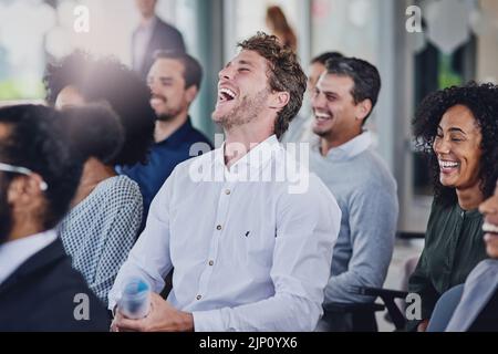 Un groupe d'hommes d'affaires se moque lors d'un séminaire dans la salle de conférence. Banque D'Images