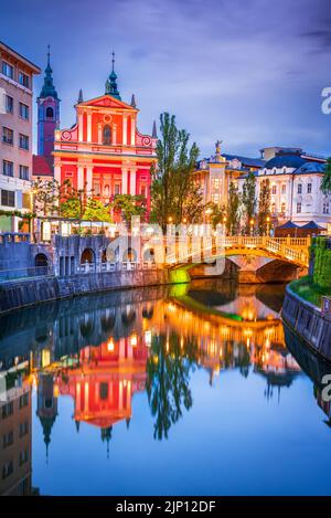 Ljubljana, Slovénie. Pont triple, réflexion sur l'eau de Tromostovje sur la rivière Ljubljana, toile de fond slovène. Banque D'Images