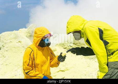 les volcans sur la pente du volcan étudient des échantillons de minéraux sur fond de fumaroles de soufre fumarales Banque D'Images