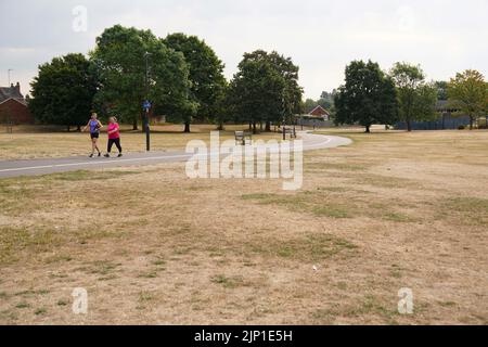 Les gens marchent à pied à côté de l'herbe parchée au parc St Nicholas à Warwick, alors que le Royaume-Uni se prépare pour trois jours de pluie et d'avertissements météorologiques jaunes. Date de la photo: Lundi 15 août 2022. Banque D'Images